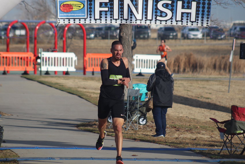 Carl Arnold resets his watch after finishing first at the 37th Brighton Turkey Trot Nov. 21. He posted a time of 16:16 in the 5K race. The first female finisher was Noelle Green. Her time was 19:31. More than 500 runners and walkers participated in this year's event.